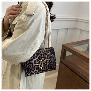 Detailed side view of leopard print crossbody bag with gold chain strap and metal buckle