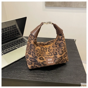 Détail du sac léopard avec garniture en cuir marron et fermeture par fermoir métallique