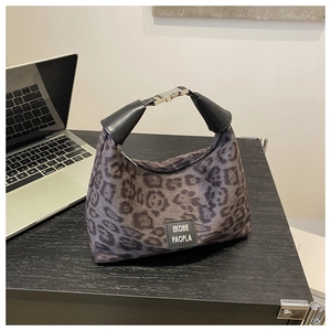 Détail du sac hobo léopard montrant la texture du tissu, la poignée et la boucle en métal