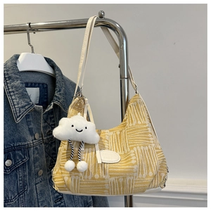 Detail of yellow and white striped shoulder bag with a cute white cloud plush pendant