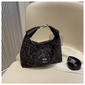Détail du sac léopard avec boucle argentée et étiquette de marque en cuir noir