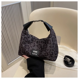 Détail d'un sac bandoulière à motif léopard avec tissu de qualité et poignée en cuir