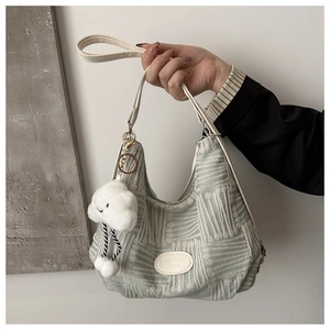 Detail of light green jacquard hobo bag with white leather trim and plush cloud charm