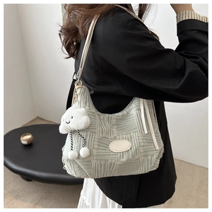 Detail of mint green canvas bag with geometric texture and cute white cloud pendant