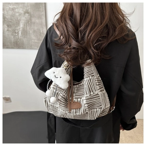 Detail of jacquard bucket bag with leather logo patch and plush cloud charm