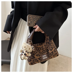 Détail du sac léopard avec coque de téléphone assortie et charme d'ours en peluche