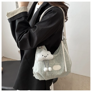 Detail of light green jacquard bucket bag with wavy texture and white cloud charm accessory