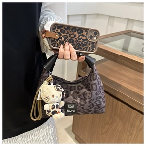 Détail du sac à main léopard avec coque de téléphone et pendentif en peluche assorti