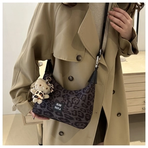 Détail du sac hobo à motif léopard avec bandoulière et accessoire peluche de chat
