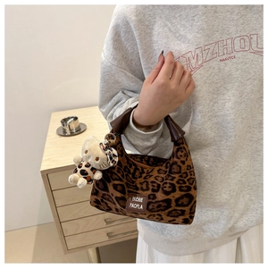 Détail du sac à main léopard en peluche avec texture fausse fourrure et breloque chat