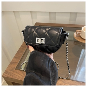 Macro detail of black quilted leather mini bag with silver chain strap and metal lock