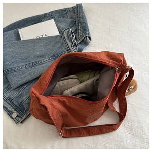 Detailed interior of red nylon tote bag showing spacious storage for phone and wallet