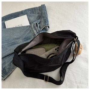 Detail view of large black commuter tote bag showing spacious interior with daily essentials
