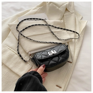 Detail of black quilted crossbody bag with silver metal twist lock and chain strap