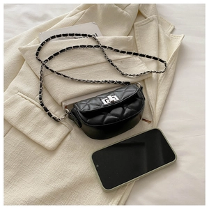 Détail macro du mini sac matelassé noir avec fermoir argenté et bandoulière chaîne