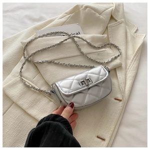 Detailed close-up of a mini silver quilted chain bag with a metal twist-lock buckle