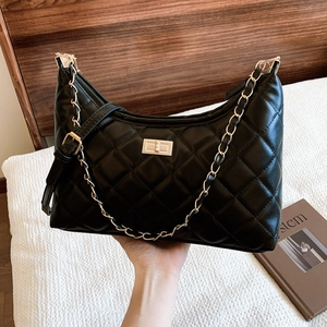 Vintage quilted black tote bag with gold chain strap and turn-lock closure in hobo style