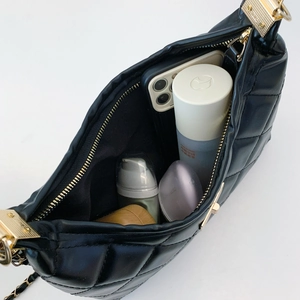 Quilted black leather tote bag with gold chain strap showing spacious interior capacity