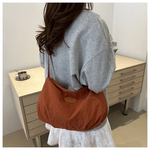 Hobo bag detail showing the fashion leather patch and durable soft nylon texture