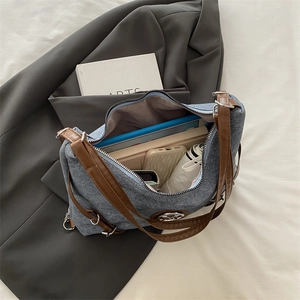 Blue denim tote bag with leather straps and large capacity for daily essentials