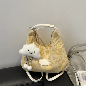 Yellow canvas bucket bag with white abstract patterns and cloud charm accessory