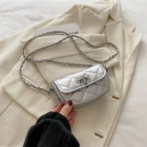 Mini sac à bandoulière argenté matelassé avec chaîne sur une veste de costume beige