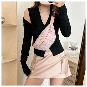 Pink and white striped crossbody chest bag styled with a pink satin midi skirt