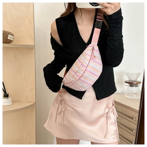 Detail showing colorful pink and yellow striped canvas belt bag with adjustable strap