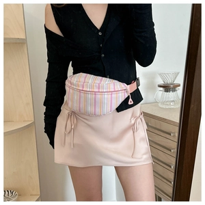 Close-up of pink striped waist bag crossbody on model with twill fabric texture