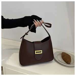 Detailed view of the dark brown leather baguette bag with a stylish gold buckle accent