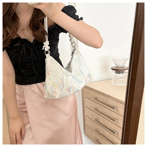 Detailed embroidery with rainbow wavy lines on white canvas tote with woven rope handle