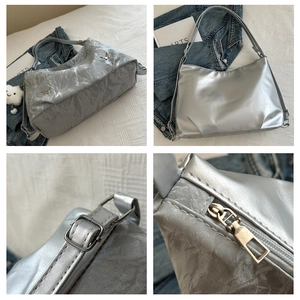 Detail view of silver tote bag showing metallic texture, butterfly buckle and cloud charm