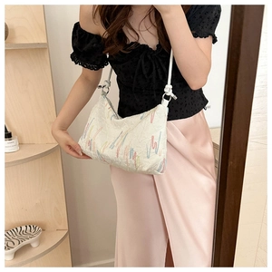 Detail of white shoulder bag with colorful line embroidery and slim strap for summer style