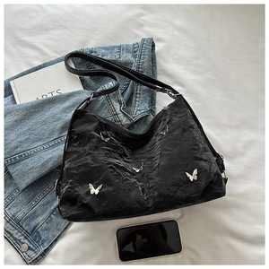 Close-up of black textured tote bag featuring five 3D silver metal butterfly charms