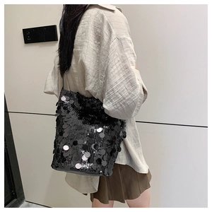 Dettaglio di una borsa a secchiello nera con grandi paillettes circolari riflettenti