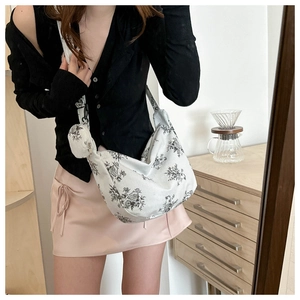 Detail of white corduroy tote bag with black floral print and matching round coin purse