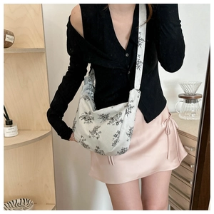 Detail of white corduroy hobo bag with vintage floral print and wide strap for daily wear