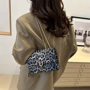 Chic leopard print chain shoulder bag with gold hardware worn over a stylish blazer