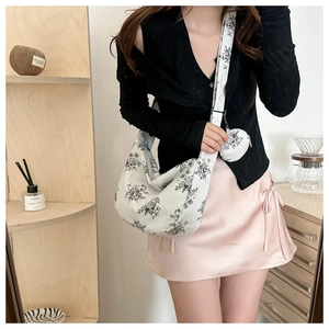 Detailed macro of vintage floral print dumpling bag with matching mini round coin purse