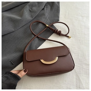 Detail der dunkelbraunen Leder-Baguette-Tasche mit halbmondförmigem Goldmetallverschluss