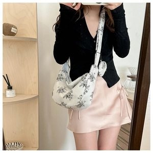 Detail of white corduroy half-moon crossbody bag with floral print and mini coin purse