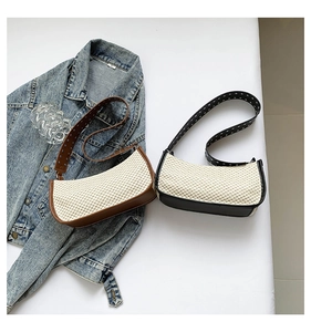 Detailed view of woven crescent shoulder bags with leather straps and silver metal studs