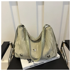 Detail of light green wrinkled leather shoulder bag with silver butterfly charms