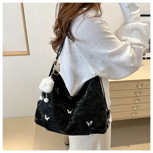 Detail of black pleated tote bag with silver butterflies and cloud plush charm