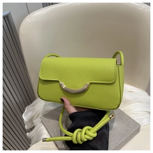 Detail of neon green baguette bag featuring woven rope strap and gold-tone metal buckle