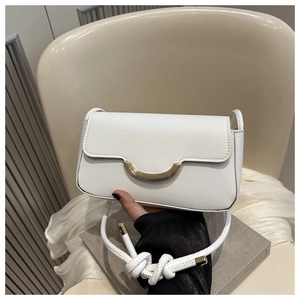 Detail of white faux leather baguette bag with golden metal buckle and rope shoulder strap