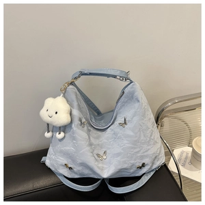 Detail of light blue pleated backpack with silver butterflies and cloud charm