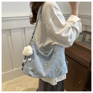 Détail du sac en nylon bleu clair avec papillons argentés et peluche de nuage