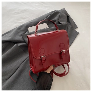 Detailansicht der glänzenden roten PU-Ledertasche mit Zierschnallen und Tragegriff