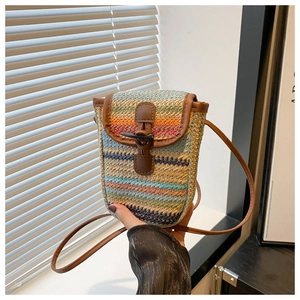 Macro detail of colorful woven texture and horn buckle on a summer crossbody phone bag